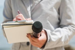 wywiad – dziennikarka z mikrofonem i notatnikiem