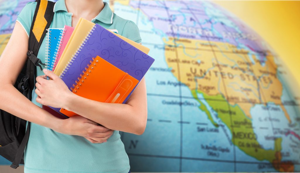 Student na Erasmusie, z książkami i zeszytami, zmierza na wykłady