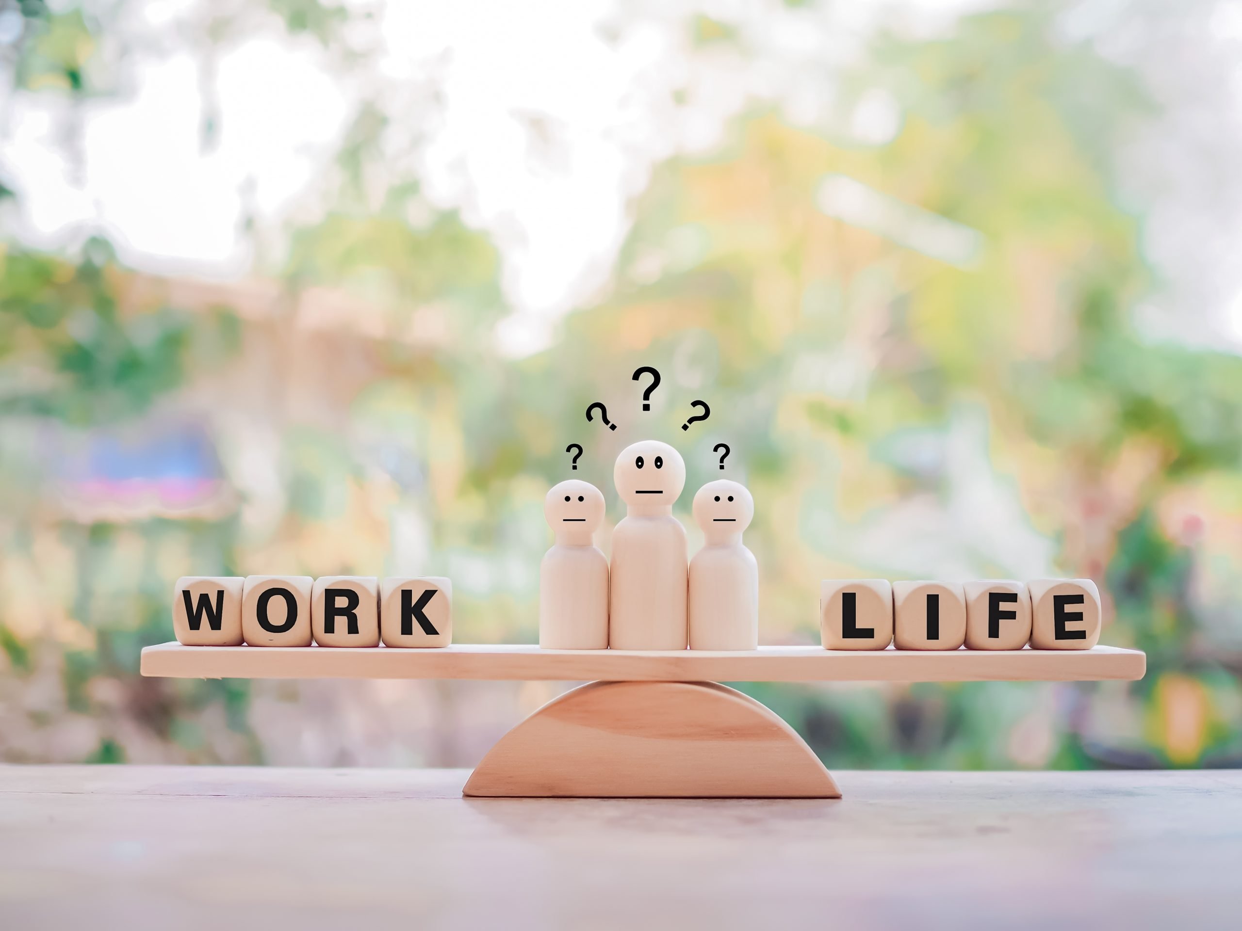 Ilustracja drewnianej wagi, obrazującej work-life balance.