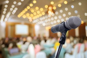 wystąpienia publiczne – zdjęcie mikrofonu na pierwszym planie, w tle sala