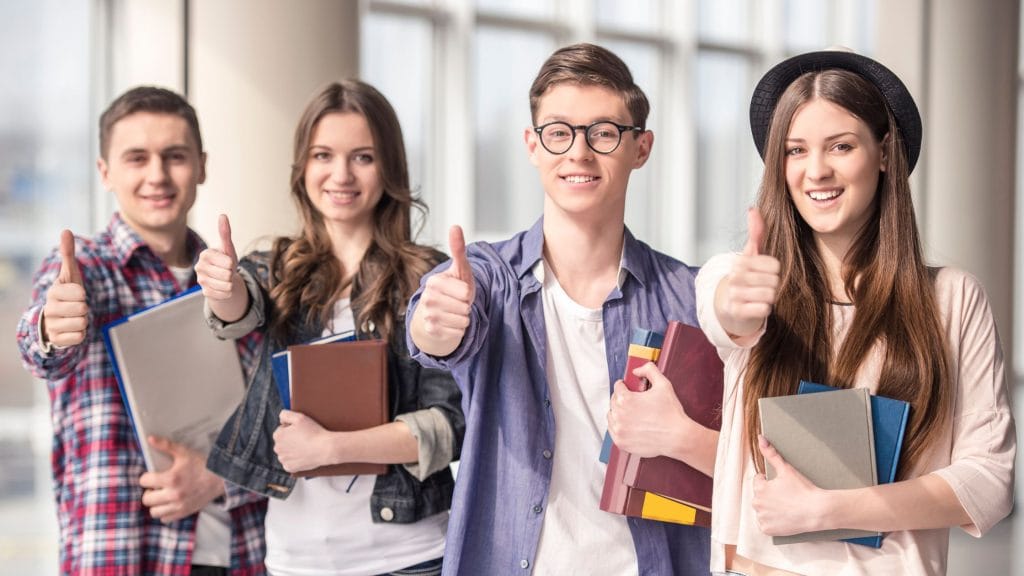 Studia dzienne czy zaoczne? Która opcja jest lepsza dla Ciebie? 2 uśmiechnięci młodzi ludzie mężczyźni i kobiety w roli przyszłych studentów